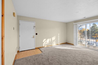 Empty room with light carpet and a textured ceiling