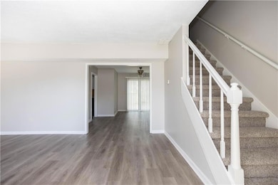 Staircase with baseboards, a ceiling fan, and wood