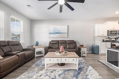Living area with a ceiling fan and wood finished floors