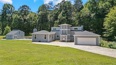 View of front of home with a chimney, a front lawn, concrete driveway, an outdoor structure, and crawl space