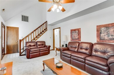 Living room with a ceiling fan, stairway, carpet f