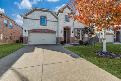 French country style house featuring a front lawn, concrete driveway, stone siding, an attached garage, and brick​​‌​​​​‌​​‌‌​​‌​​​‌‌​​​​​​‌‌‌​​‌​​‌‌​​​‌ siding