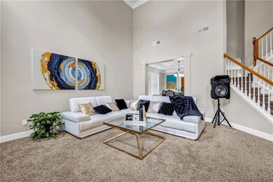 Living area featuring ornamental molding, baseboards, stairs, carpet, and a chandelier