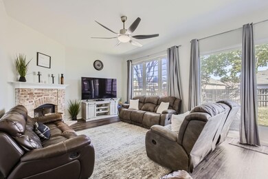 Living room featuring ceiling fan, a fireplace, an
