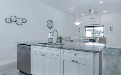 Kitchen featuring light stone counters, a sink, ba