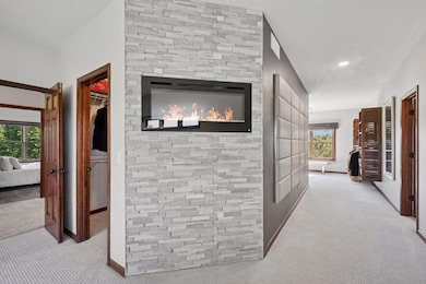 Primary suite features fireplace with floor to ceiling stone surround, two large walk in closets and sitting area.