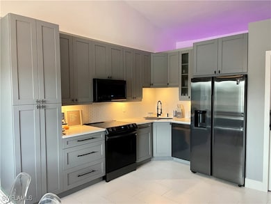 Kitchen featuring black appliances, backsplash, gr