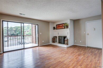 Full view of family room with adorable corner fireplace and bright sliding doors onto private terrace.