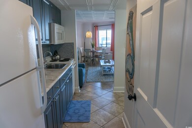 Kitchen with white appliances, blue cabinets, a sink, tasteful backsplash, and light countertops