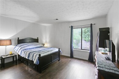 Bedroom featuring wood finished floors and a textured ceiling