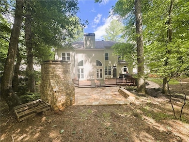 Rear view of property featuring a deck, a patio, a