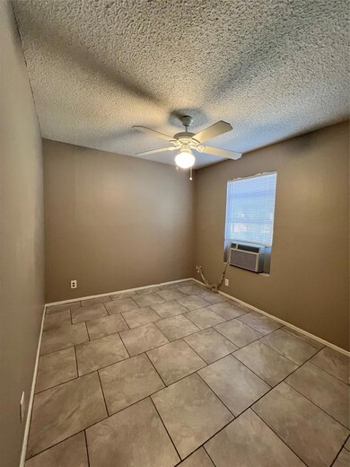 Tiled empty room with baseboards, cooling unit, a