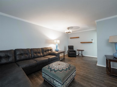 Living room with crown molding and dark wood-type 