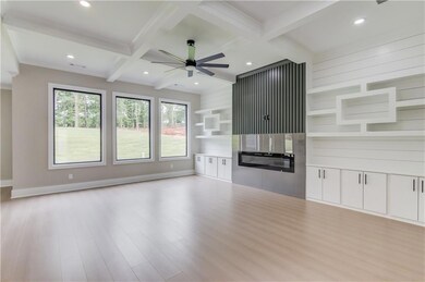Unfurnished living room with beam ceiling, light wood finished floors, coffered ceiling, a ceiling fan, and recessed lighting
