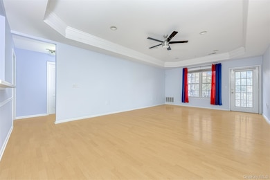 Living Room featuring a raised ceiling, crown molding, light wood-style floors, ceiling fan, and recessed lighting