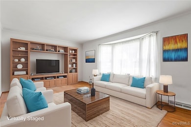 Living room light wood-style floors and crown mold