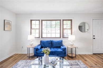 Living area with healthy amount of natural light and wood finished floors
