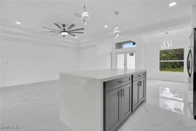 Kitchen featuring light marble finish floors, appliances with stainless steel finishes, recessed lighting, a center island, and gray​​‌​​​​‌​​‌‌​​​‌​​‌‌​‌‌​​​‌‌‌​​​​‌​​​​​‌ cabinetry