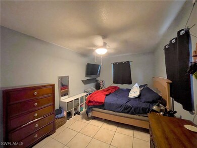 Bedroom with light tile patterned flooring and cei