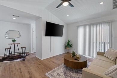 Living area with wood finished floors, vaulted ce