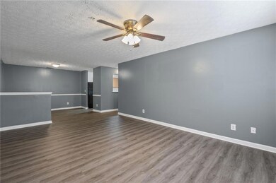 Spare room featuring a ceiling fan, dark wood-type flooring, and a textured ceiling