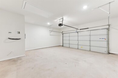 Garage with baseboards and a garage door opener