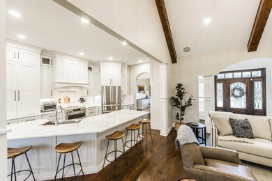 The luxury kitchen features custom cabinetry, quartzite counters, and a GE Cafe double oven with electric range!