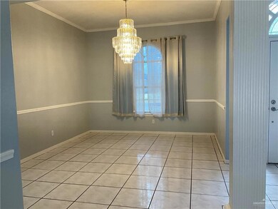 Empty room featuring light tile patterned floors, a chandelier, and crown molding