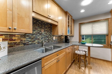 A peninsula-style island with seating enhances both function and flow, while a side door offers convenient access to the backyard.