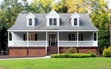 Cape cod home featuring a porch and a front yard
