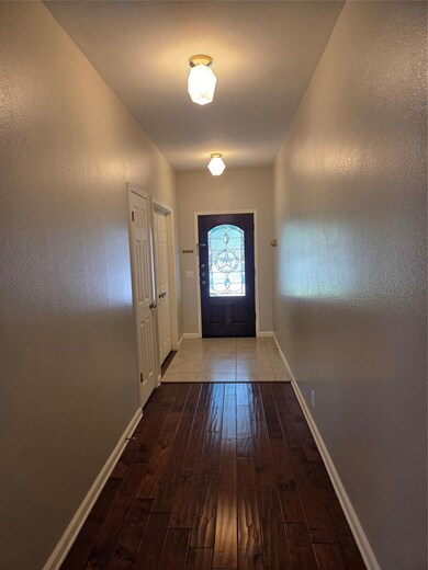 Doorway to outside with a textured wall and hardwood / wood-style flooring