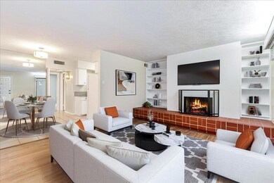 Living room featuring a warm lit fireplace, light