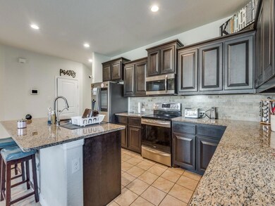 Kitchen featuring light stone counters, an island 