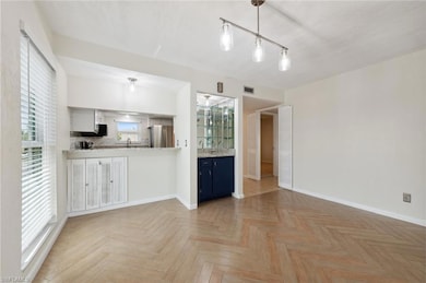 Kitchen featuring freestanding refrigerator, baseboards, blue cabinets, light countertops, and a sink