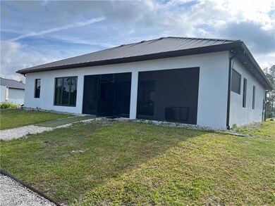 Rear view of property featuring a yard, stucco sid