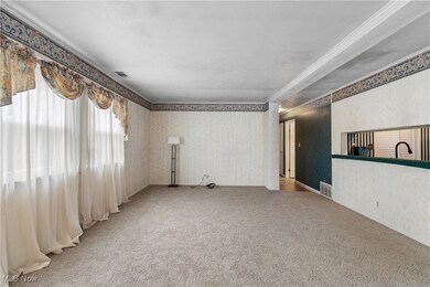 Unfurnished living room with wallpapered walls and light carpet