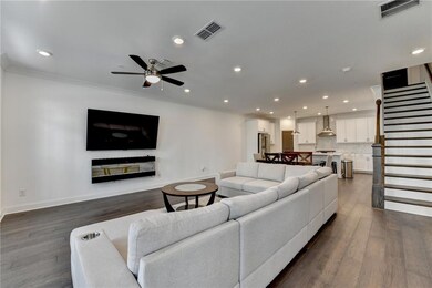 Living area featuring ceiling fan, stairway, ornamental molding, dark wood-style floors, and recessed lighting