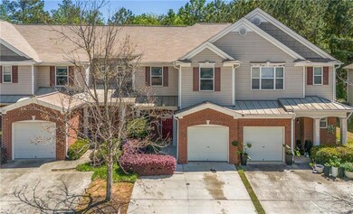 View of property featuring concrete driveway, bric