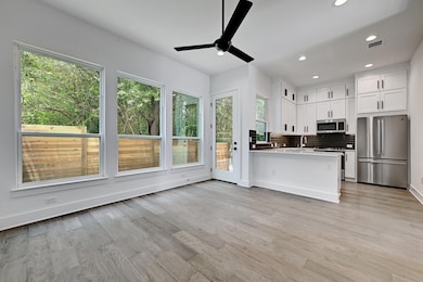 Kitchen featuring ceiling fan, backsplash, white 