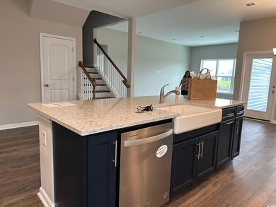 Kitchen featuring dishwasher, light stone countert