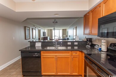 Kitchen with black appliances, dark stone countert