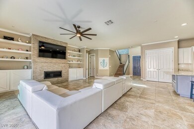 Living area with a large fireplace, a ceiling fan,