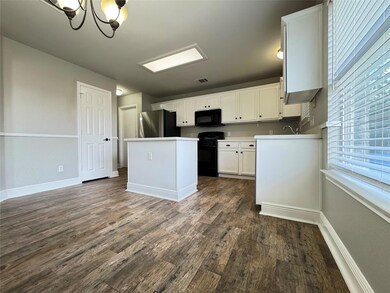 Kitchen featuring black appliances, dark wood fin