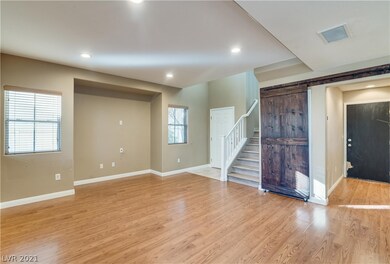 Living room with barndoor to storage under stairwa