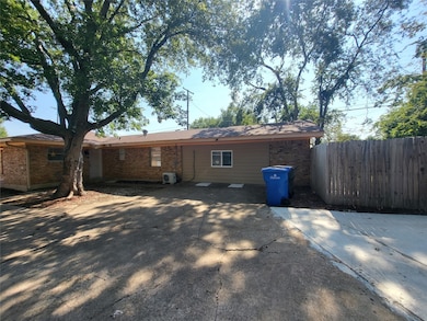 Back of property with a patio and brick siding