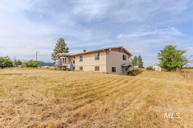 Rear view of house featuring a lawn, a chimney, and a storage unit