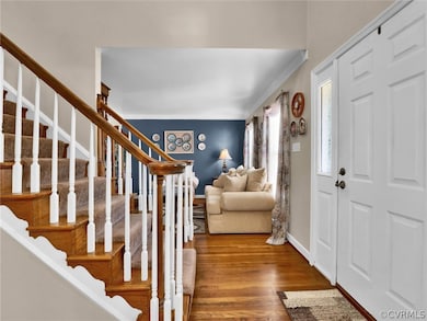 Foyer with wood-type flooring and crown molding