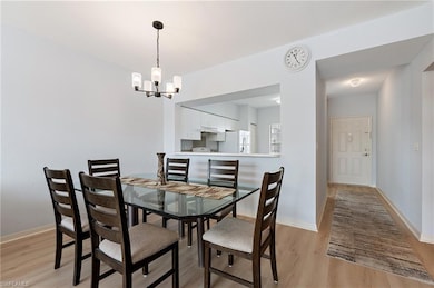 Dining room featuring light wood finished floors and a chandelier