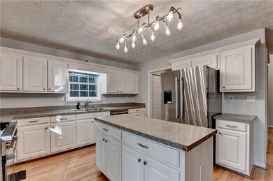 Kitchen with white cabinetry, light wood-style flo