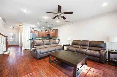 Living room featuring ornamental molding, dark wood finished floors, recessed lighting, stairway, and ceiling fan